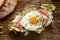 Ham and fried egg open sandwich, Sourdough bread sandwich with lettuce, ham and fried egg on a rustic wooden table