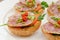 Ham sandwiches with chili, parsley and scallion on white plate c