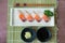 Hamachi sushi on white plate along with Japanese sauce and green leaf decoration, Japanese food, Top view at sushi