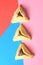 Hamantash filled-pocket cookie recognizable for triangular shape for Jewish holiday of Purim on red and blue background.