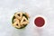 Hamantashen cookies or Aman ears, triangular cookies with poppy seeds in two colored buckets on gray background and hot tea