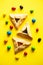 Hamantashen - Festive baking for Jewish holiday of Purim. Traditional cookies with different fillings and candies on a yellow