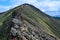 Hamar-Daban, stone rock with colored moss on a sharp ridge in Baikal green mountains, Siberia, Chersky peak