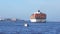 HAMBURG, GERMANY - MARCH 8th, 2014: large container ship on water with harbor docks in background under blue sky