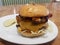 Hamburger with cheese on plate with bacon and stuffed peppers