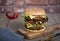 Hamburger with a double serving of meat, tomatoes, salad, onions on a wooden board in a restaurant.Copy space