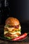 Hamburger with a double serving of meat, tomatoes, salad, onions on a wooden board in a restaurant.Copy space