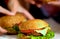 Hamburger fast food with ham on wooden board. Blurred background.