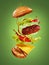 The hamburger with flying ingredients on green background