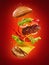 The hamburger with flying ingredients on red background