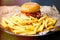 Hamburger with golden french fries on plate