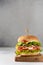 Hamburger with ham, tomato and lettuce, selective focus. Side view, copy space. Junk fast food, snack