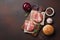 Hamburger ingredients raw cutlets, lettuce, bun and onion on rusty background