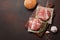 Hamburger ingredients raw cutlets, lettuce, bun and onion on rusty background