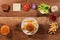 Hamburger ingredients on wooden table with an assembled burger i