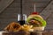 Hamburger, onion ring and french fries with cold drink on chopping board