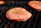 Hamburger patties grilling on an outdoor barbecue