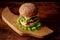 Hamburger wooden curly board. Dark wooden background. Hamburger day