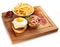 Hamburgers and French fries on the wooden tray.