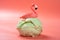 hami melon flavor ice cream ball with a flamingo on top on a pink background