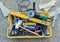 Hammer, screwdriver and electric cutter inside the toolbox of a construction worker.