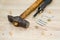 Hammer, screwdriver and fasteners on wooden table. tools and parts for assembling cabinet furniture