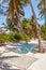 Hammock on the beach set between two trees with shadow on white