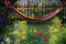 Hammock with colorful stripes hanging in the morning sun among the apple trees below it blooms bee meadow sowing annuals for plent