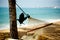 Hammock relaxation on beach with crow and ocean