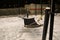 A hammock strung between two metal poles with snow on the ground