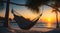 hammock strung between two palms on tropical island beach with the sunset