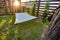 Hammock suspended between two pines in summer garden of country house at sunset