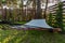 Hammock suspended between two pines in summer garden of country house at sunset