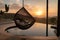 hammock swing hanging next to pool with view of the setting sun