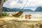 A hammock between two palm trees on the beach. Beautiful beach. The concept of rest and recreation. Beautiful tropical island.