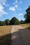 Hampstead heath Park pathway, stunning cloudy blue sky.