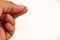 Hand of an acupuncturist holding a long thin acupuncture needle. Man`s hand and metal needle