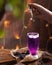 Hand adding flavor to the vibrant purple colored liquid beverage on the wooden table