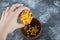 Hand adding popcorn seeds into a wooden bowl