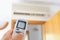 Hand adjusting temperature of home air conditioner