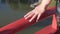 Hand of adult woman caressing top of red bridge in Japanese Garden