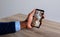 Hand of african american man holding smartphone, view of warehouse from security cameras on screen