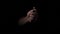 The hand appears from the dark and turns on the lighter and disappears.