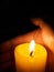 Hand around illuminated candle