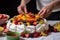 hand arranging sliced fruits on a pavlova