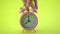 Hand asian male picking pink alarm clock place on yellow table indoor studio shoot isolated on yellow background