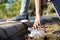 Hand of asian people is picking up trash,litter on the public floor,child girl was bending down to collect plastic bottle garbage