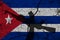 Hand assault rifle on the background of the flag of cuba and cracks. cuba Power Concept