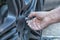 A hand attaching a screw to the wheel of a car