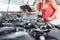 Hand of an auto mechanic opening the oil reservoir while checking a car